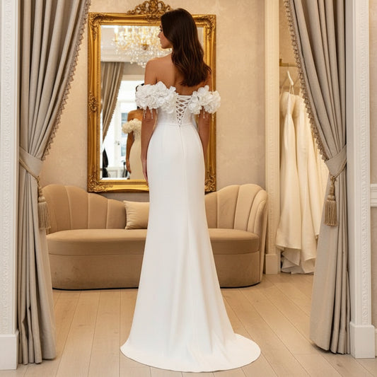 White off-shoulder wedding dress, side view, floral sleeve details and flowing long skirt