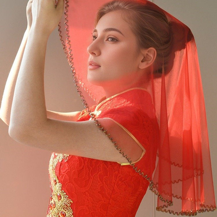 Red short bridal veil head cover with beaded trim, flowing veil over shoulders