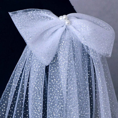 White wedding dress with glitter shoulder bows and sheer tulle drape
