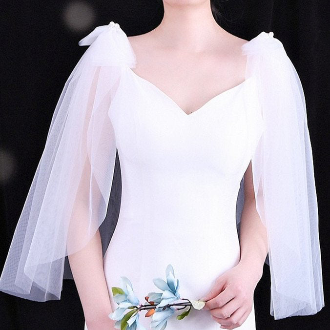 White wedding dress with V-neck bodice and sheer tulle shoulder bows with pearl accents