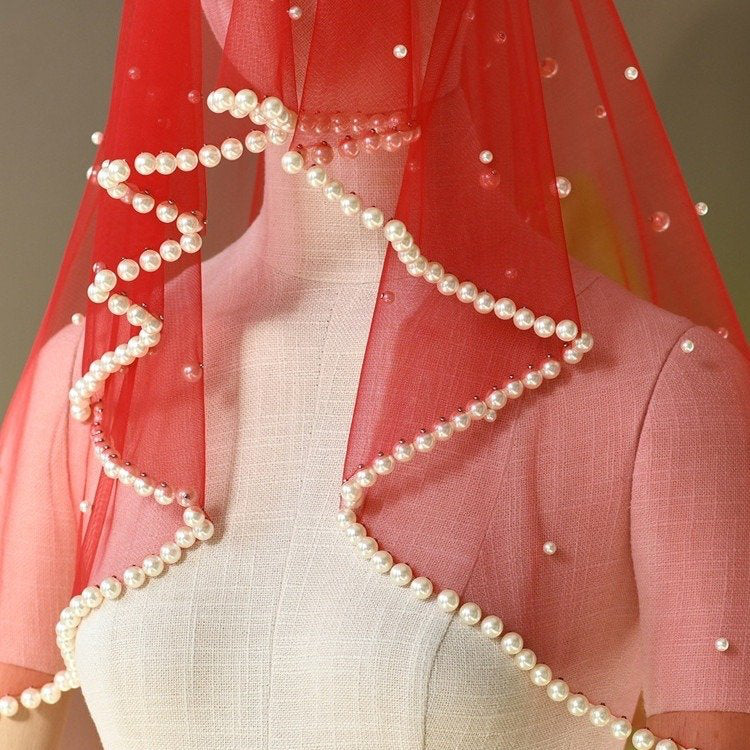 Red short veil with pearl trim and bead accents, draped over shoulders
