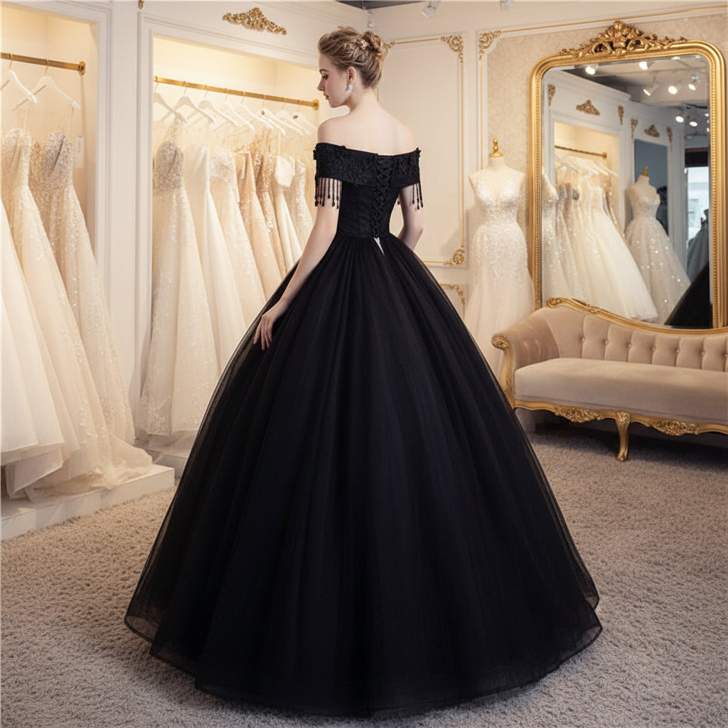Black off-shoulder ball gown with lace bodice, fringe details, and full tulle skirt