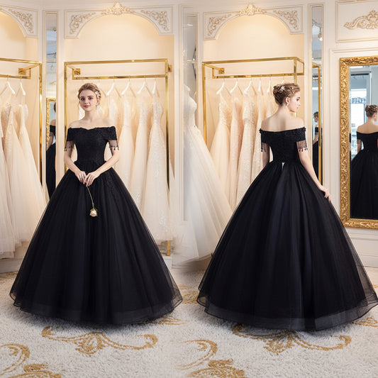 Black off-shoulder ball gown with lace bodice, fringe sleeves, and full tulle skirt